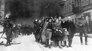 گروهی از یهودیان لهستانی که به دست سربازان آلمان نازی تبعید می‌شوند