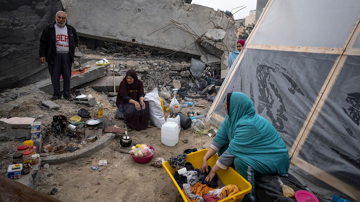 Palestinians displaced by the Israeli bombardment of the Gaza Strip cook and wash clothes at the makeshift tent camp in the Muwasi area on Thursday, Dec. 28, 2023.