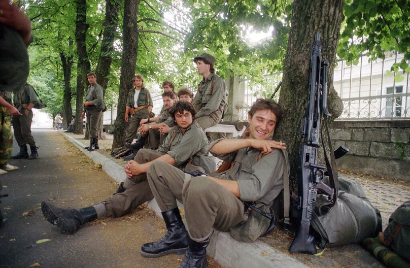 Soldiers of the Slovenian militia have a rest after the federal army of Yugoslavia withdraw from this small town near the Italian border in Sezana, July 1991