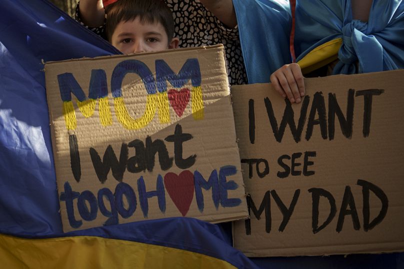 Ukrainian children hold banners during a protest outside the Russian embassy in Bucharest, October 2023