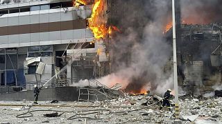 Los bomberos tratan de extinguir un fuego este viernes en un edificio dañado por un ataque ruso en Kiev