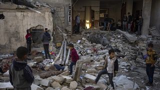 ينظر الفلسطينيون إلى الدمار الذي خلفه قصف إسرائيلي جنوب غزة، الجمعة، 29 ديسمبر 2023.
