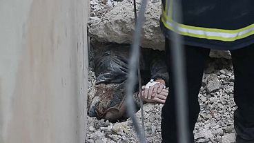 Les secouristes extraient des décombres un homme piégé sous un bâtiment effondré à Kharkiv. 
