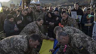 Un grupo de soldados y civiles entierran a un militar caído en la guerra con Rusia.