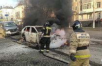 Tűzoltók oltják az égő autókat az oroszországi Belgorodban december 30.án