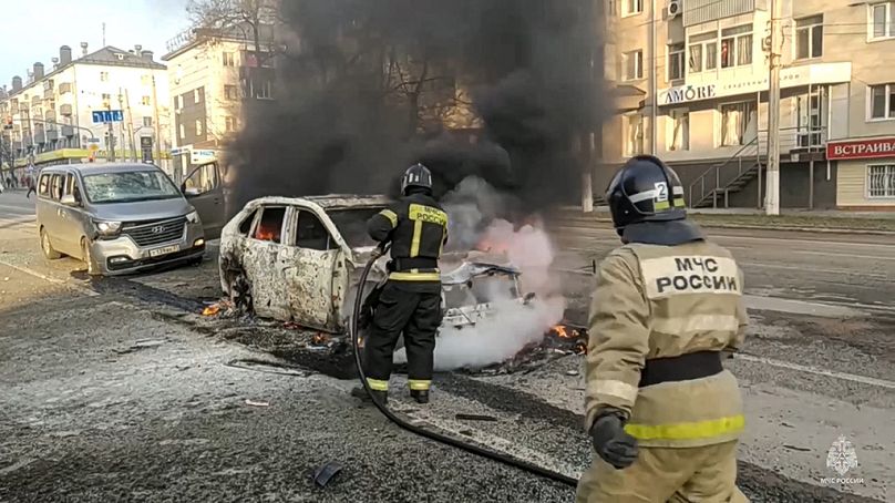Saturday, Dec. 30, 2023, Firefighters extinguish burning cars after shelling in Belgorod, Russia.