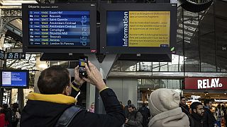 Ein Passagier fotografiert auf dem Pariser Bahnhof Gare du Nord eine Informationstafel mit gestrichenen Eurostar-Zügen, 30. Dezember 2023.