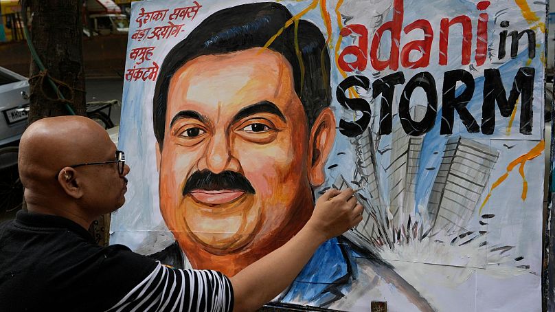 یک نقاش در بمبئی هند تصویر گوتام آدانی را در بحبوحه بحران در فوریه ۲۰۲۳ می‌کشد