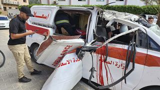 مسعفون فلسطينيون يتفقدون سيارة إسعاف متضررة أصيبت بغارة جوية إسرائيلية داخل مستشفى ناصر في خان يونس جنوب قطاع غزة، السبت 7 أكتوبر 2023.