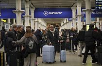 Passengers queue at the entrance to Eurostar in St Pancras International station in central London on Sunday