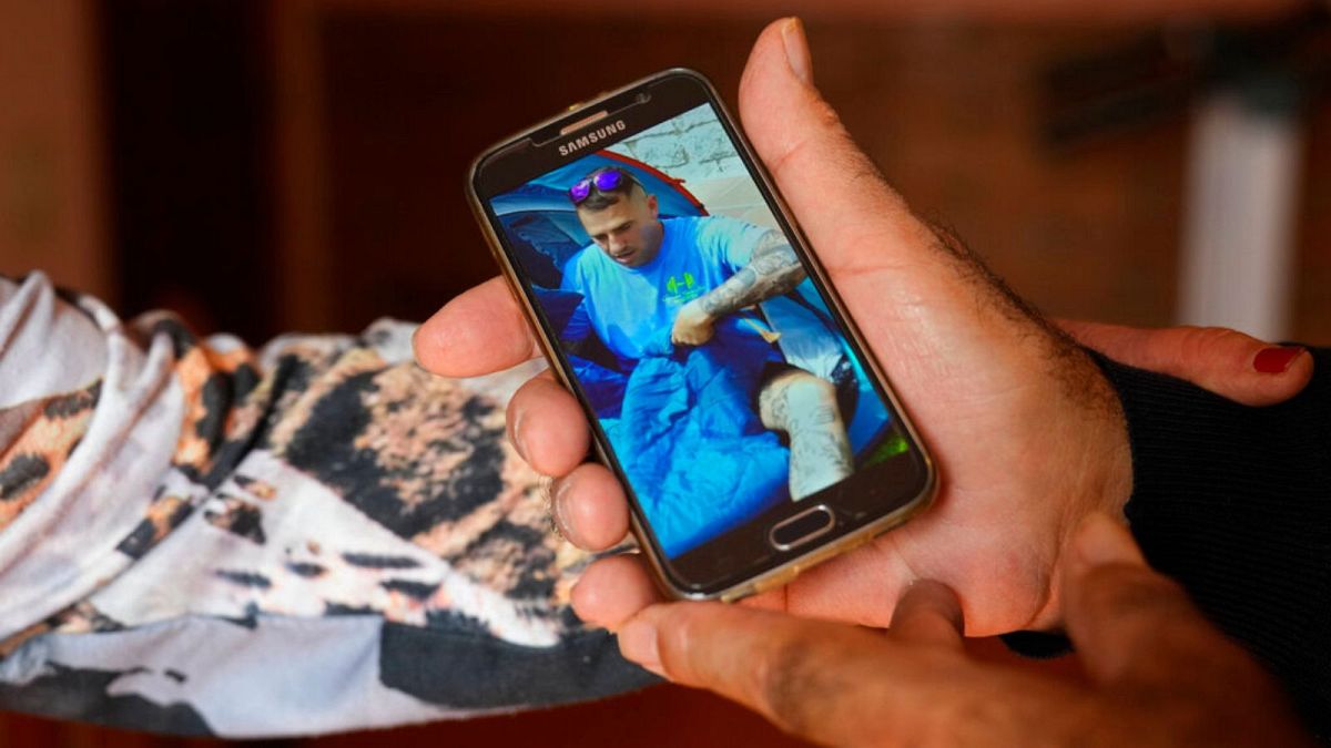 پدر سانتیاگو سانچز کوگدور عکس پسرش را بر روی موبایلش نشان می‌دهد