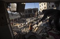 فلسطينيون يبحثون عن جثث وناجين تحت أنقاض مبنى سكني دمرته غارة جوية إسرائيلية في رفح جنوب قطاع غزة، الثلاثاء 19 ديسمبر 2023