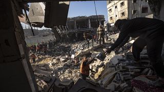 فلسطينيون يبحثون عن جثث وناجين تحت أنقاض مبنى سكني دمرته غارة جوية إسرائيلية في رفح جنوب قطاع غزة، الثلاثاء 19 ديسمبر 2023