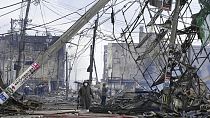  أشخاص يسيرون في السوق المتضررة التي أحرقتها النيران بعد الزلزال الذي ضرب واجيما، محافظة إيشيكاوا، اليابان، 2 يناير 2024.
