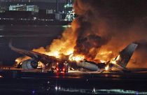 A Japan Airlines plane on fire at Haneda Airport.