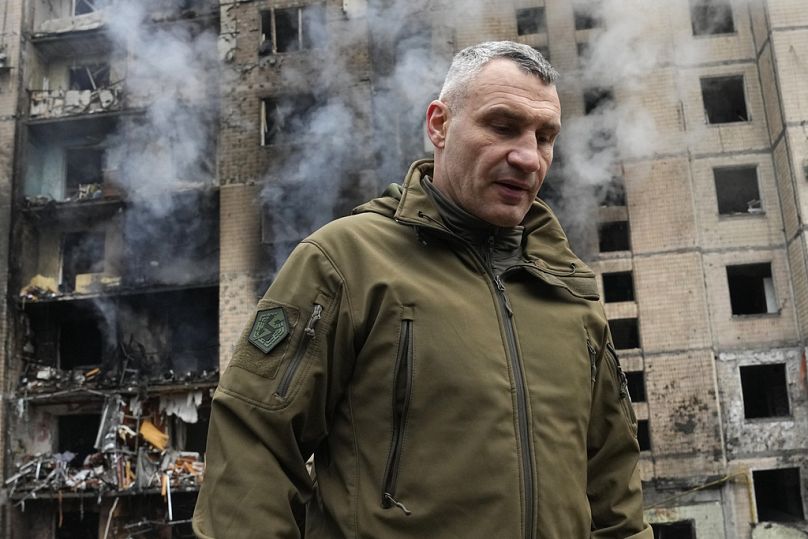 Mayor of Kyiv Vitali Klitschko inspects damages as smoke rises out from a destroyed apartment building after a Russian attack in Kyiv, Ukraine, Tuesday, Jan. 2, 2024
