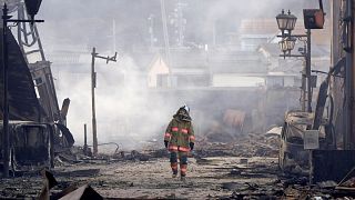 Un pompier traverse les décombres d'un marché incendié suite au tremblement de terre à Wajima, préfecture d'Ishikawa, Japon, mardi 2 janvier 2024.