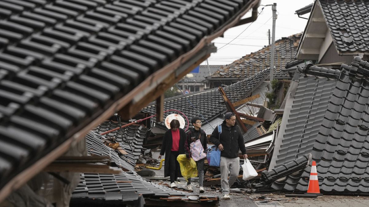 A földrengés túlélői romba dőlt házak között Szuzu városában, Icsikava régióban