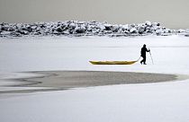 A man walks on the frozen sea in southern Helsinki, Finland, Tuesday, Jan. 2, 2024. 