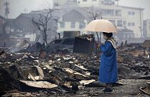 امرأة تنظر إلى السوق المحترق إثر الزلازل في واجيما - محافظة إيشيكاوا، اليابان. 2024/01/03