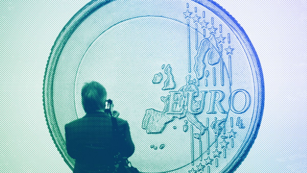Un homme prend une photo de l'œuvre d'art "Euro" du groupe d'artistes Superflex lors de la foire d'art de Cologne, en avril 2015.