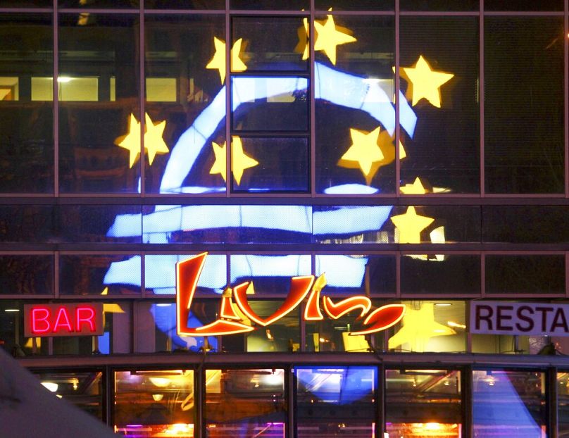 La sculpture de l'Euro se reflète dans les fenêtres de la Banque centrale européenne à Francfort, en décembre 2011.