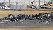 رجال الإطفاء يتجمعون حول طائرة خفر السواحل اليابانية المحترقة في مطار هانيدا الأربعاء 3 يناير 2024 في طوكيو، اليابان