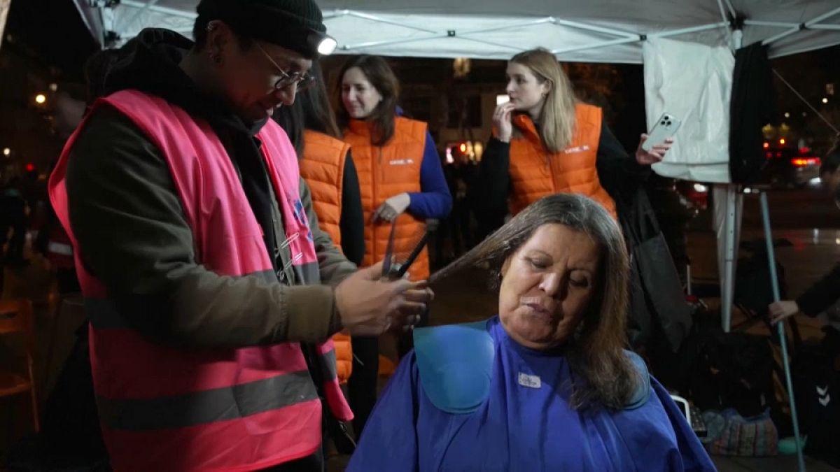 Freiwillige Friseure schneiden Obdachlosen und Bedürftigen in Paris die Haare. 