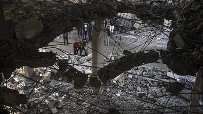 فلسطينيون ينظرون إلى الدمار الذي خلفته غارة إسرائيلية على مدينة رفح جنوب قطاع غزة. 2024/01/03