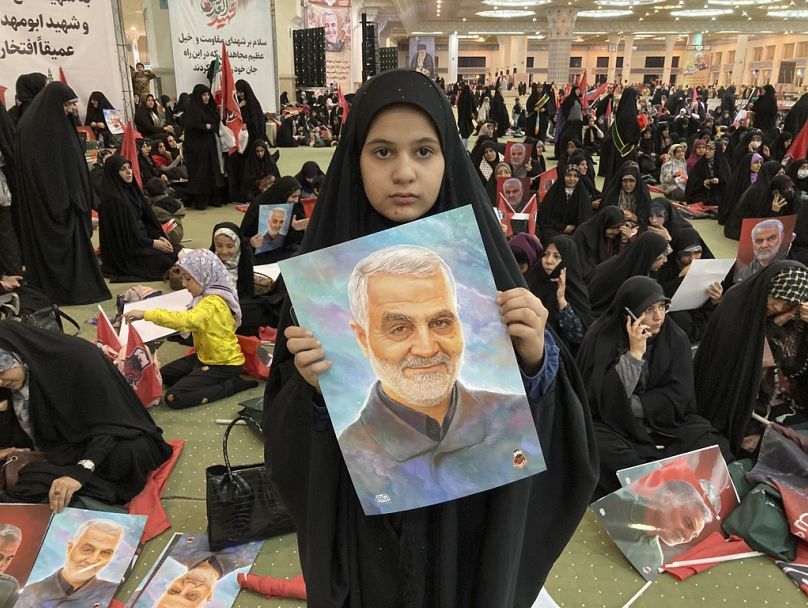 An Iranian girl holds up a portrait of the late Revolutionary Guard Gen. Qassem Soleimani.
