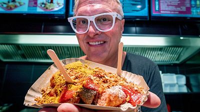 Lars Obendorfer, owner of "Best Worscht in Town" sausage holds up vegan curry wursts.