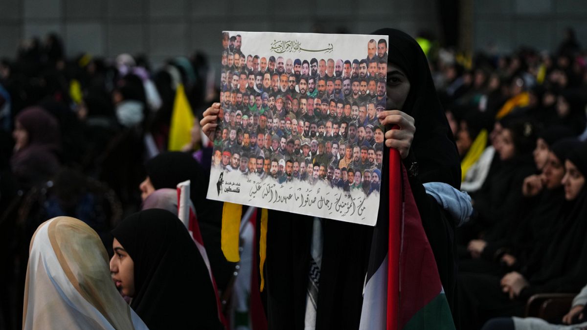 Elinde öldürülen Hizbullah üyelerinin bulunduğu bir pankart taşıyan protestocu bir kadın