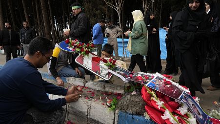 Люди зажигают свечи на месте теракта в Кермане, Иран, 4 января 2024 года.