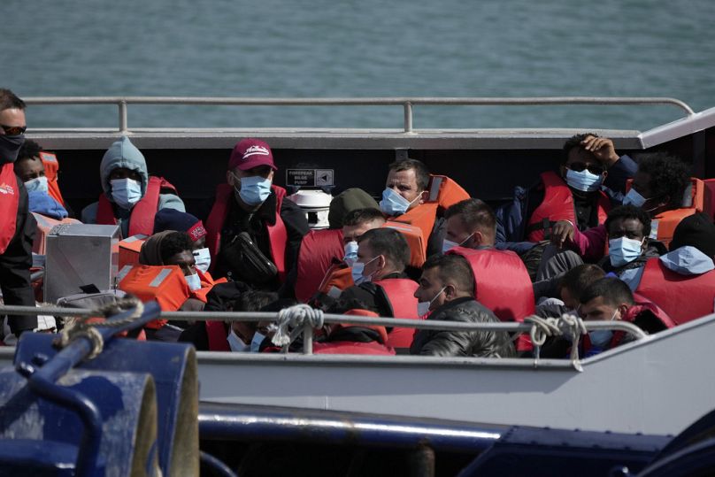 People thought to be migrants who undertook the crossing from France in small boats and were picked up in the Channel, wait to be disembarked from a British border force boat
