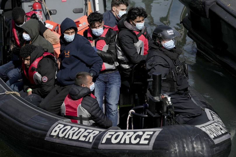 People thought to be migrants who undertook the crossing from France in small boats and were picked up in the Channel, arrive to be disembarked from a small transfer boat