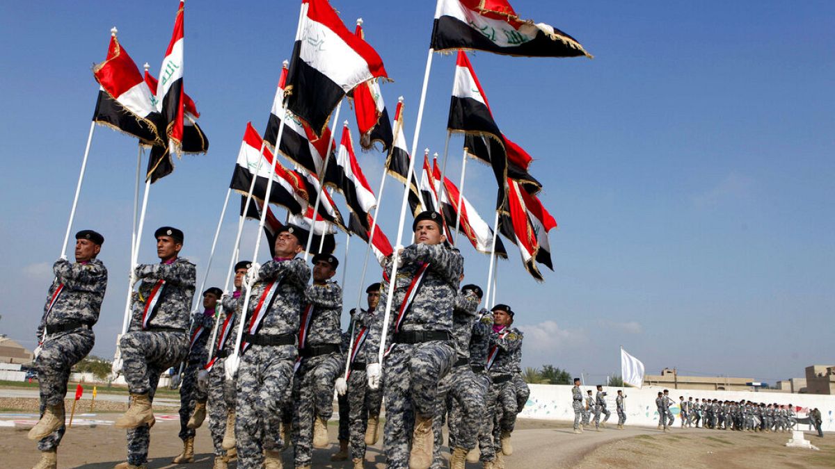 Irak bayrağı taşıyan askerler
