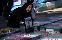 امرأة إيرانية تبكي قرب تابوت لقريب لها قتل في الانفجار