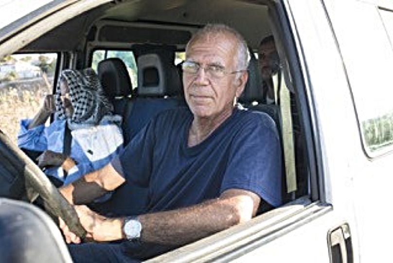 Yuval Roth, le fondateur de l'association, photographié conduisant des Palestiniens à des rendez-vous médicaux.