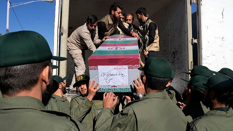Mitglieder der iranischen Revolutionsgarden entladen den mit einer Flagge bedeckten Sarg eines der Opfer des Anschlags vom Mittwoch, zu dem sich der IS bekannte.
