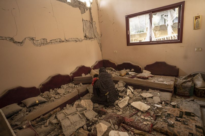 İsrail saldırısı sonrası evi yıkılan Filistinli bir kadın, geride kalan eşyalarını toplamaya çalışırken