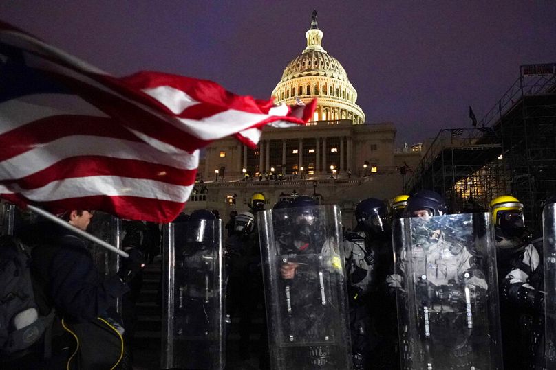 Police stand outside the Capitol after a day of rioting protesters on 6 January, 2021