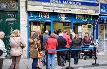 Un grupo de gente hace cola para comprar en Doña Manolita, la administración de lotería más famosa de España.