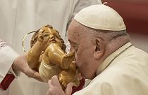 El Papa Francisco besa un niño Jesús.