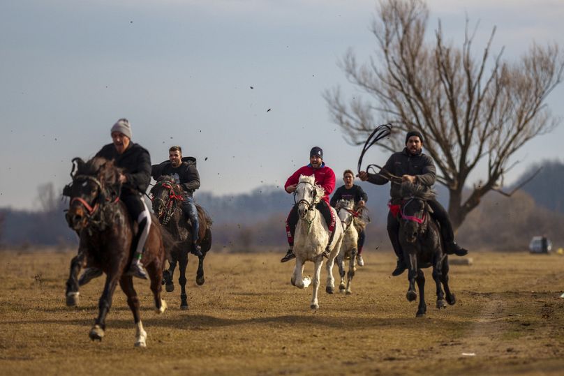People compete in a horse race during Epiphany celebrations in the village of Pietrosani, Romania, Saturday, Jan. 6, 2024.