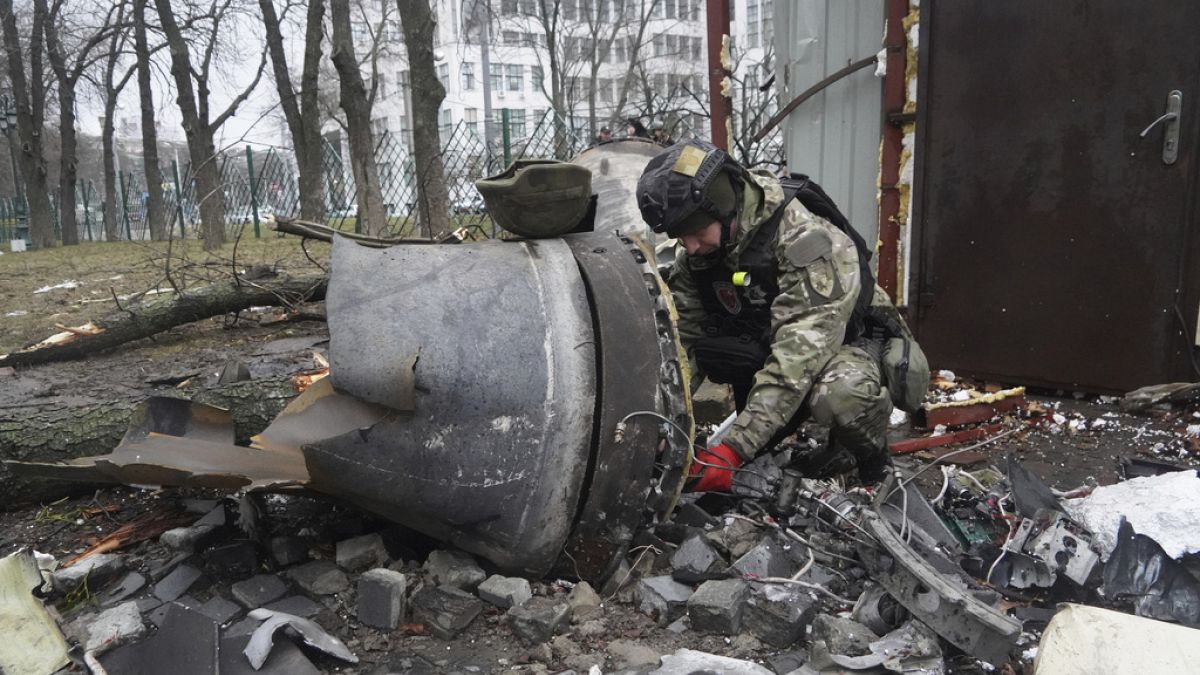 Ukraynalı bir polis memuru Harkiv'de Rus füze saldırısında hasar gören bir konutun yakınındaki roket kalıntılarınıinceliyor