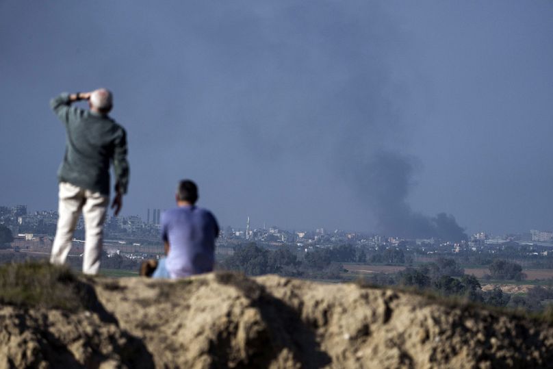 People watch smoke rising to the sky after an explosion in the Gaza Strip, as seen from southern Israel, Saturday, Jan. 6, 2024.