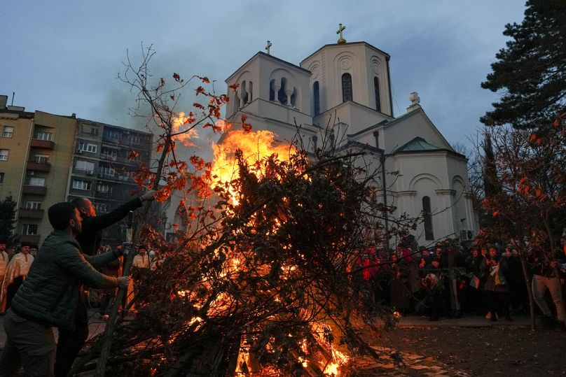 People burn dried oak branches, the Yule log symbol for the Orthodox Christmas Eve, in front of St. Sava church in Belgrade, Serbia.