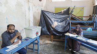 Választási tisztviselők várják a szavazókat egy szavazóhelyiségben a bangladesi Dakkában, 2024. január 7-én