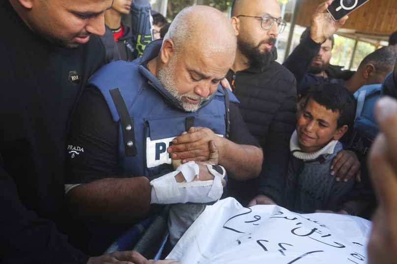 El Cezire Gazze büro şefi Velid Dahduh, İsrail saldırısında öldürülen gazeteci oğlu Hamza Dahduh'un elini tutarken