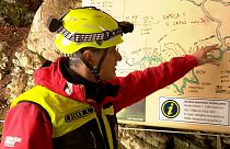 A rescuer inspects the map of Krizna Jama cave near Grahovo, Slovenia on Sunday